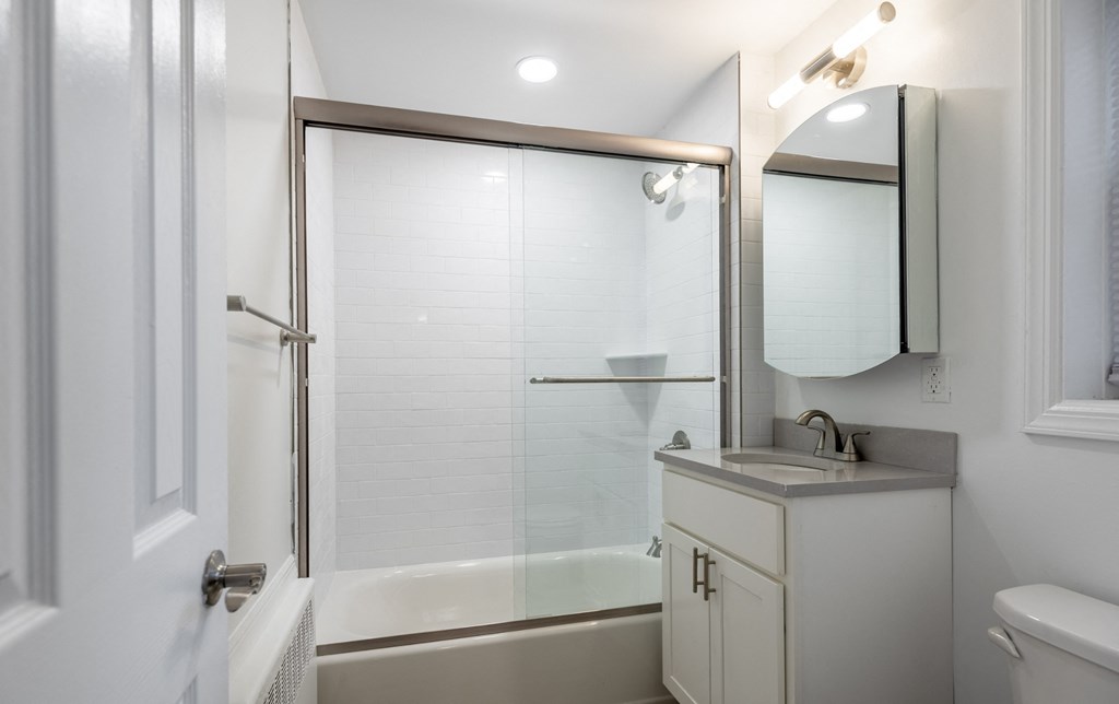 a white bathroom with a shower and a sink