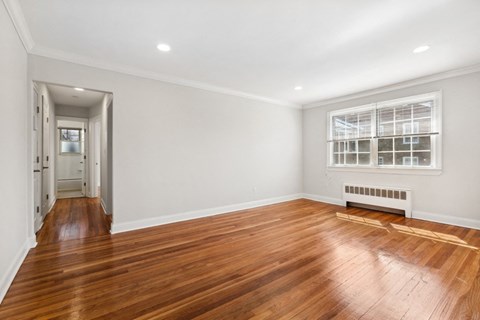 a living room with a hard wood floor and a window