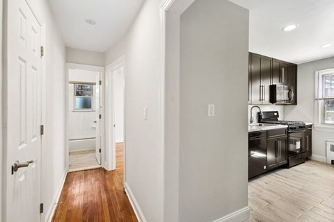 a renovated kitchen with black appliances and wood flooring in a new home