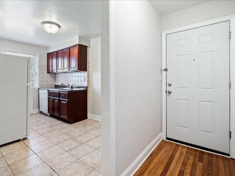 A kitchen with white appliances and brown cabinets.
