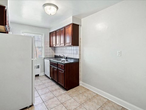 A kitchen with white appliances and brown cabinets.