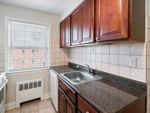 A kitchen with brown cabinets and a granite countertop.