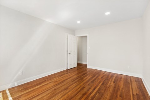 a living room with wood floors and white walls