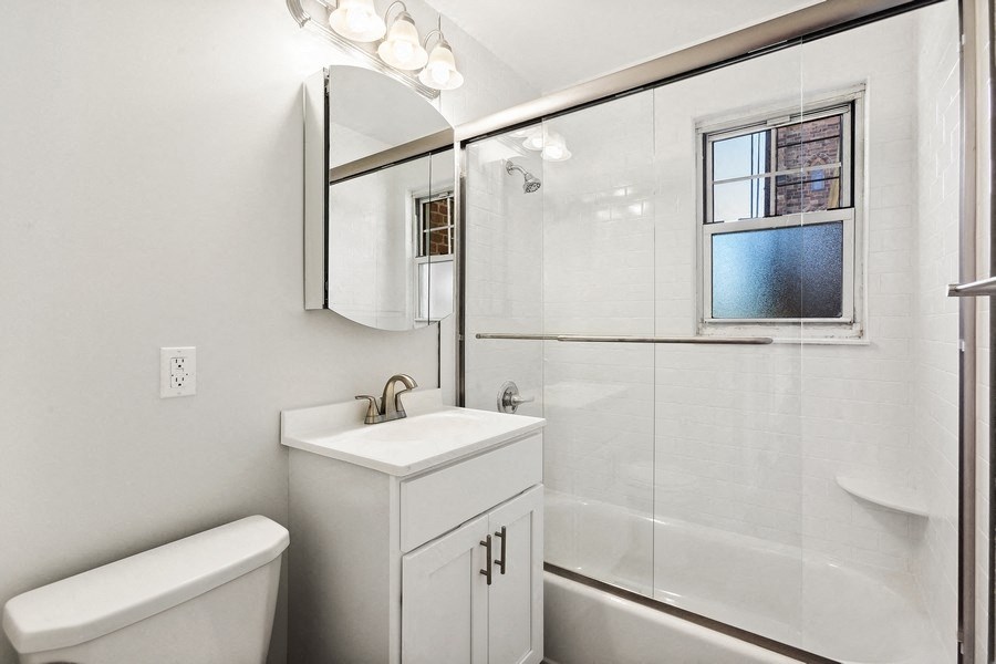 a bathroom with a shower and a sink and a toilet