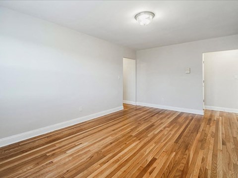 A room with wooden flooring and white walls.