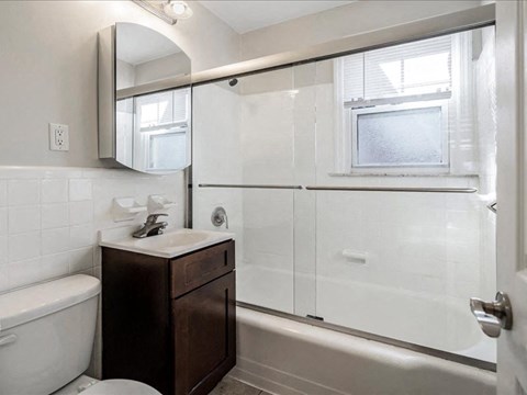 A white bathroom with a toilet, sink, and bathtub.