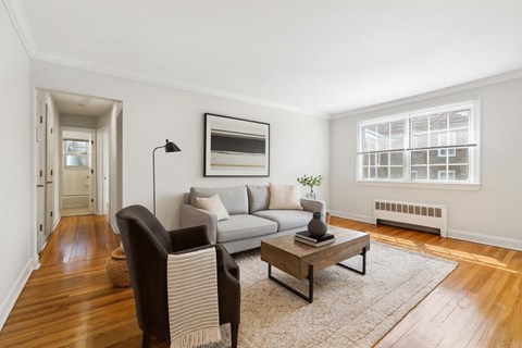 A living room with a grey couch, a brown chair, and a coffee table.