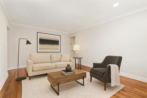 A living room with a black chair, a white sofa, and a coffee table.