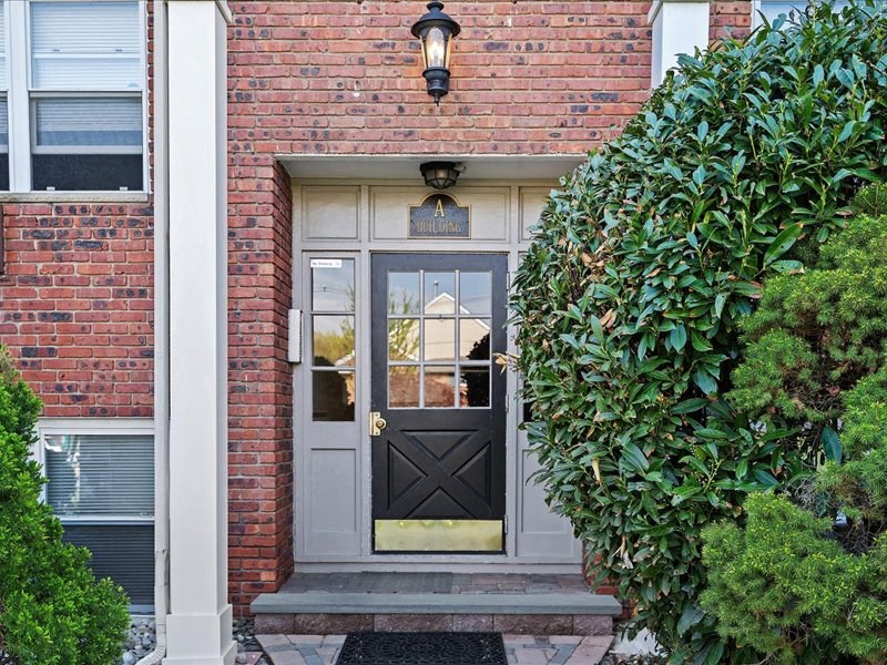 A house with a grey door and a black window.