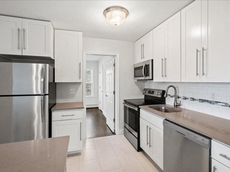 A kitchen with white cabinets and stainless steel appliances.