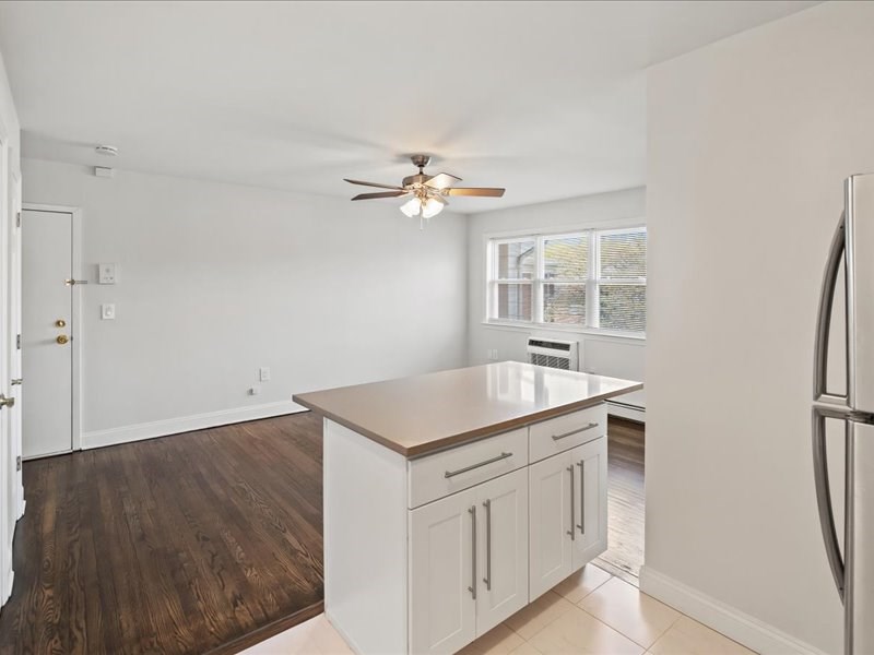 A kitchen with white cabinets and a wooden island.