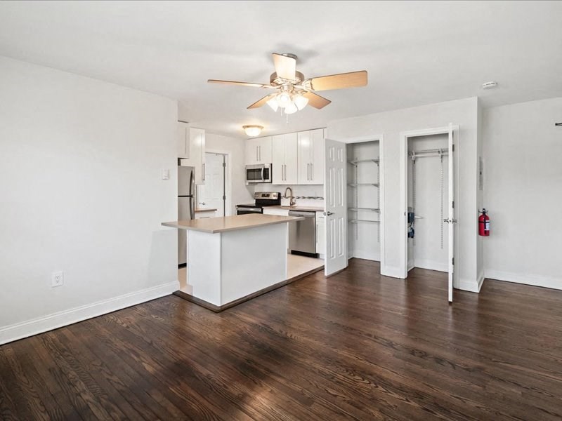 A kitchen with a white island and wooden floors.