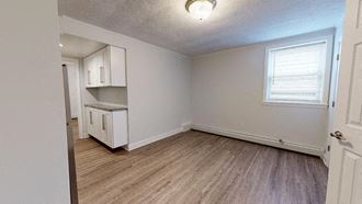 an empty living room with a kitchen in it