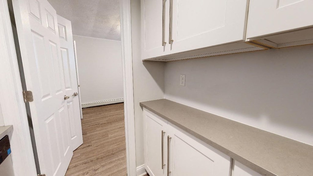 a kitchen with white cabinets and a white door