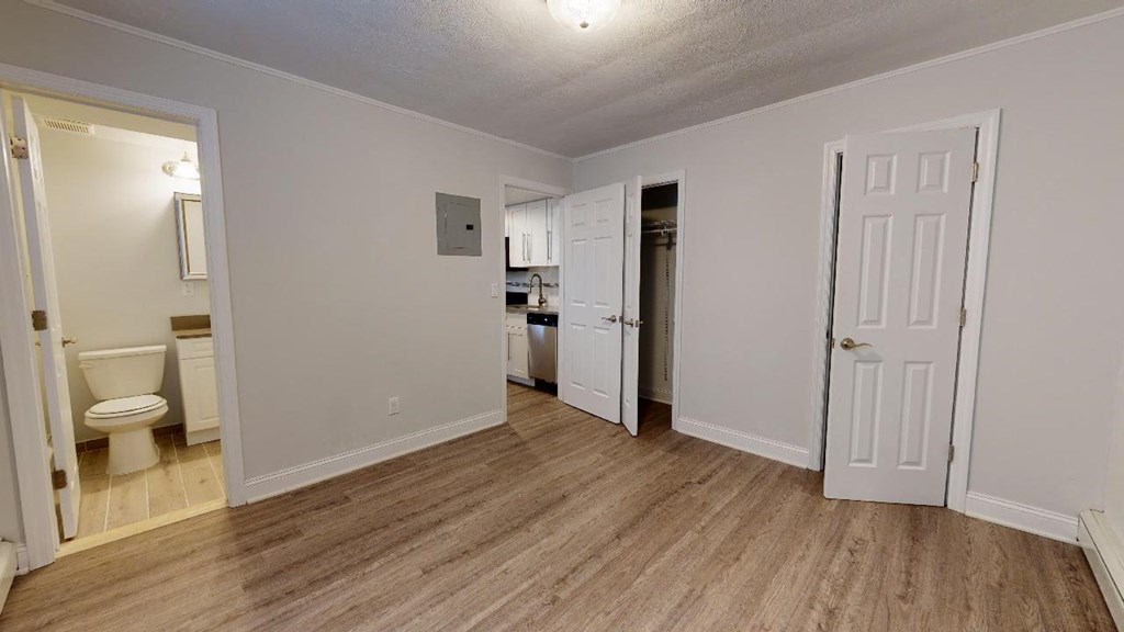 a bedroom with a door to a bathroom and a closet