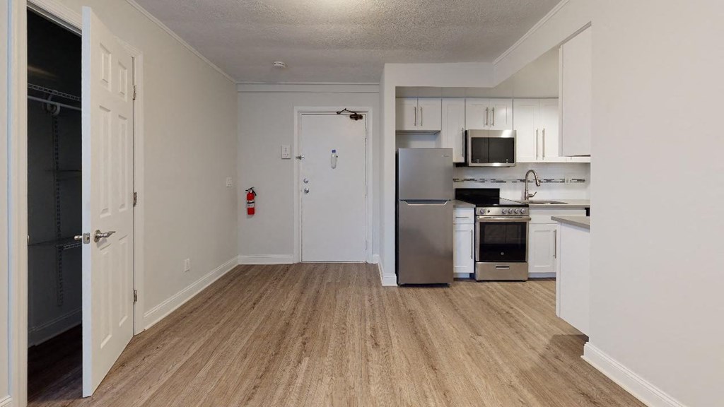 an empty kitchen with a refrigerator and a stove