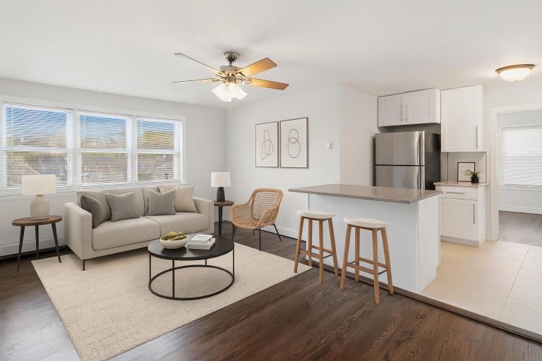 A modern living room with a kitchen area in the background.
