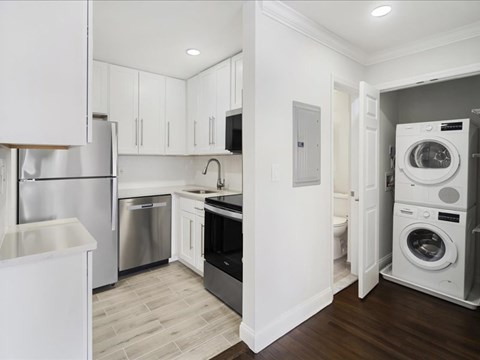 A modern kitchen with white cabinets and stainless steel appliances.