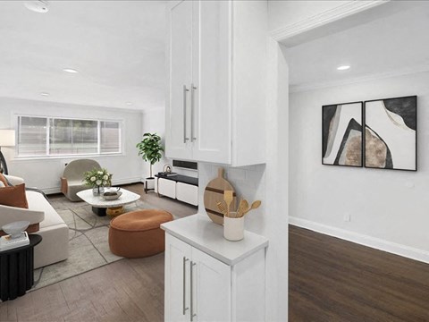 A modern kitchen with white cabinets and a wooden counter.