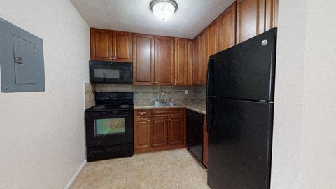 a kitchen with black appliances and wooden cabinets