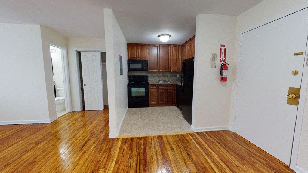 an empty kitchen and living room with wood flooring and