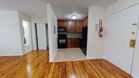 an empty kitchen and living room with wood flooring and