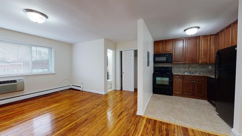 an empty kitchen with wood floors and black appliances