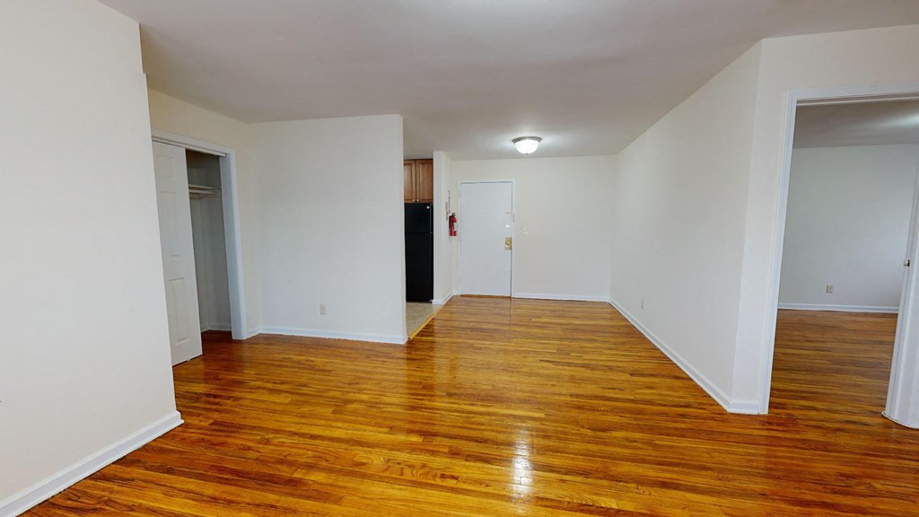 a empty living room with wood floors and white walls