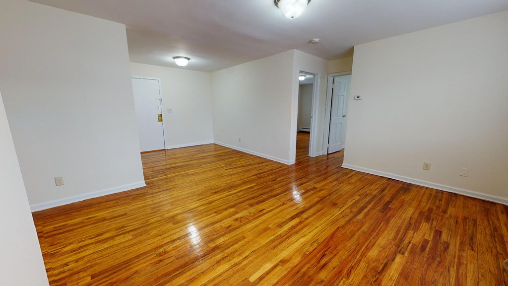 a living room with a hard wood floor and white walls