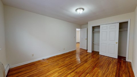 a living room with a wood floor and a door to a closet
