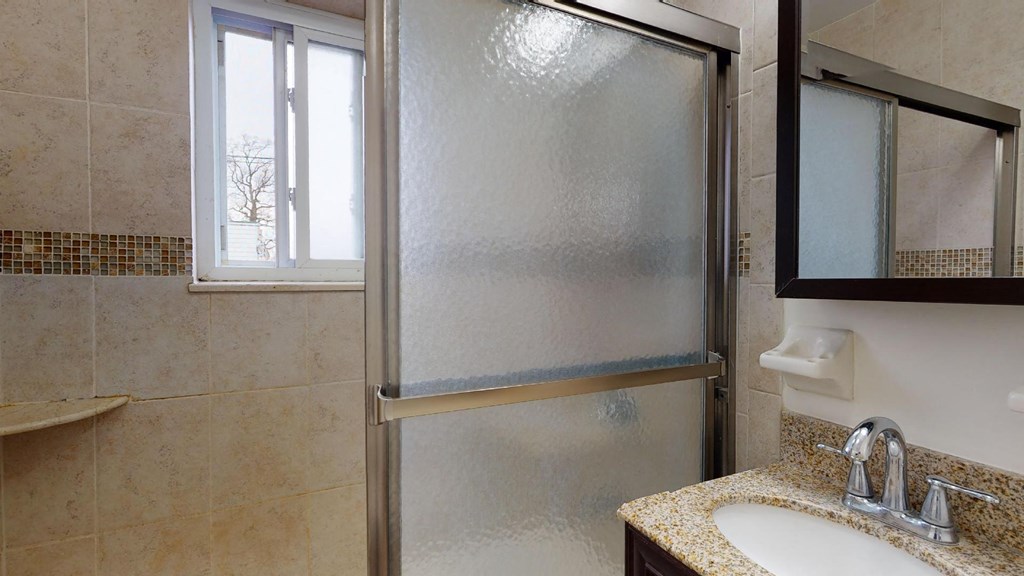 a bathroom with a shower and a sink and a mirror