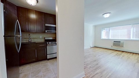 an empty kitchen and living room with wood flooring