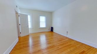 a living room with a hard wood floor and a white door