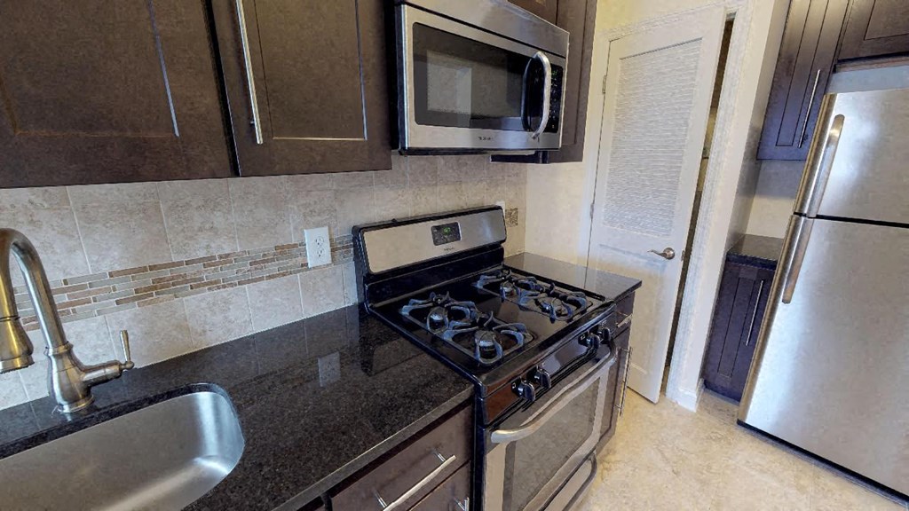 a kitchen with a stove and a microwave and a sink