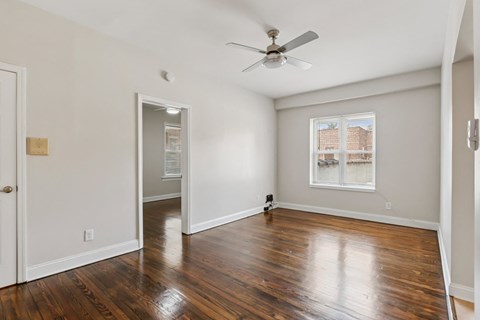 A room with a ceiling fan and a window.
