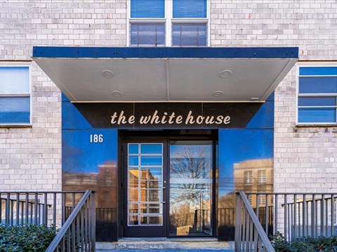 The front of a building with a sign that says "The White House" and a black door.