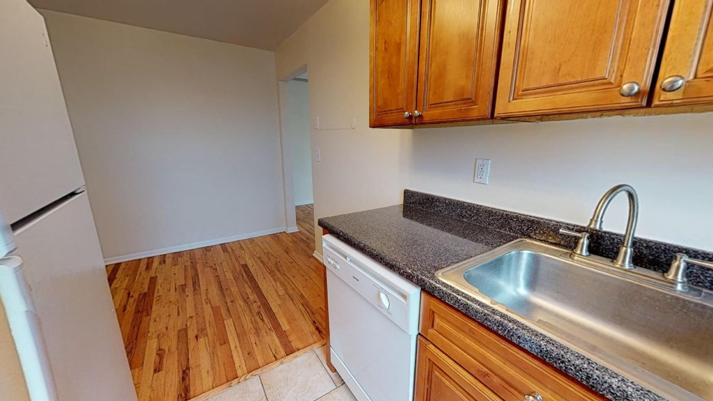 a kitchen with a sink and wooden floors