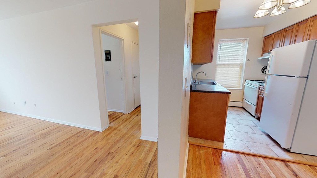 a kitchen with a wooden floor and a white refrigerator