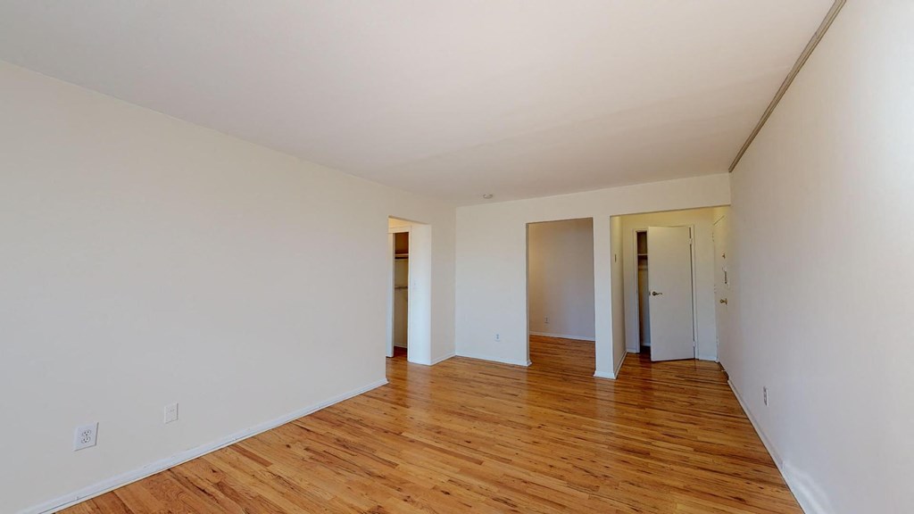 a living room with a hard wood floor and white walls