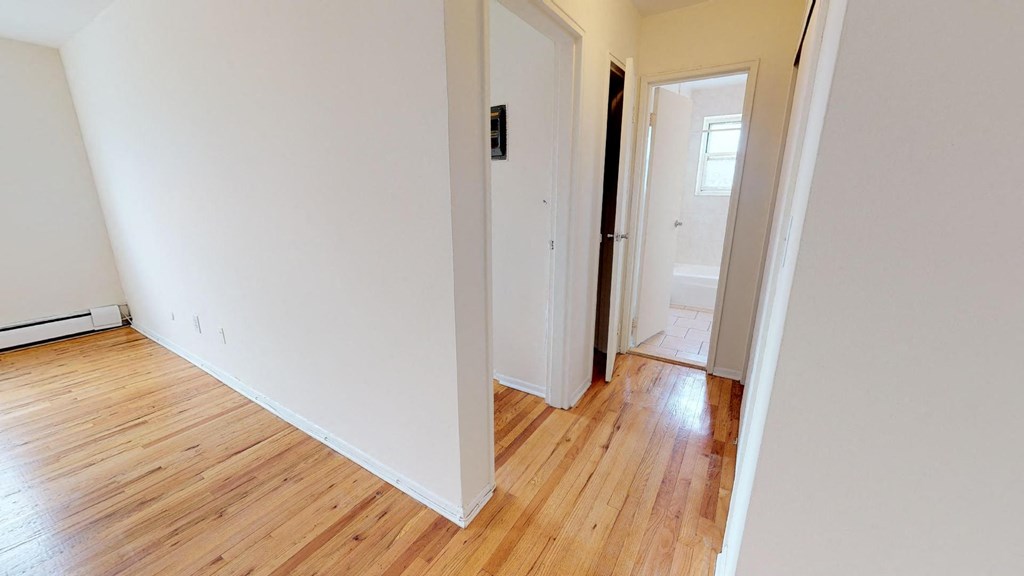 a room with a hard wood floor and white walls