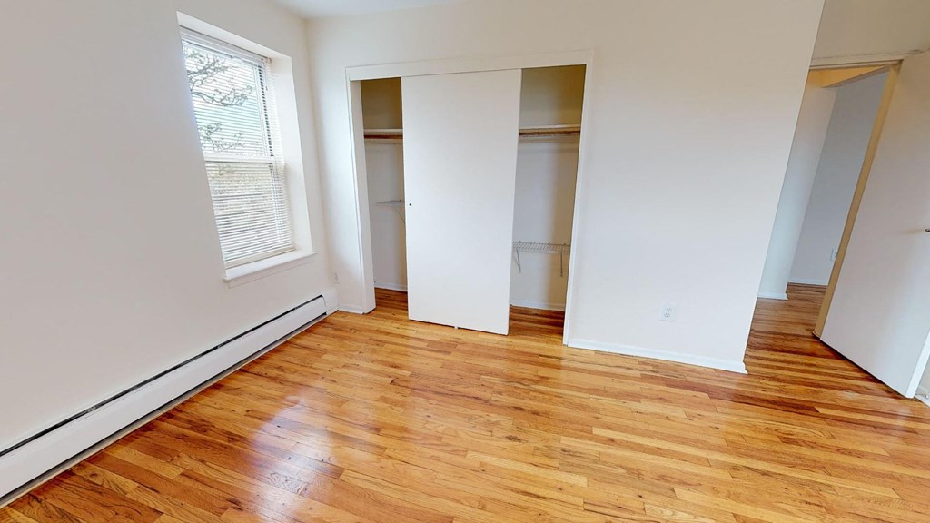 a living room with a hard wood floor and a closet