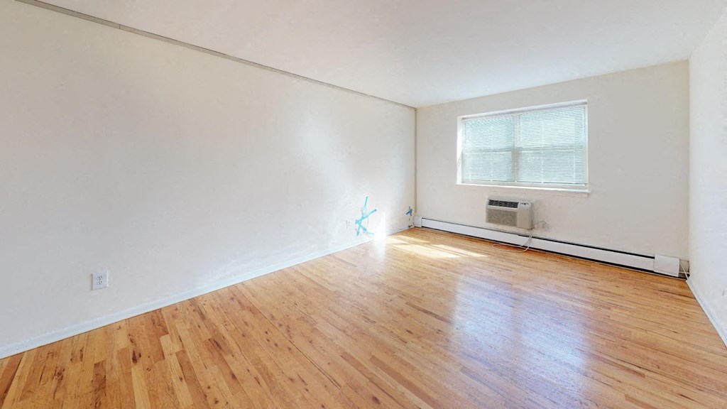 an empty room with a hard wood floor and a window