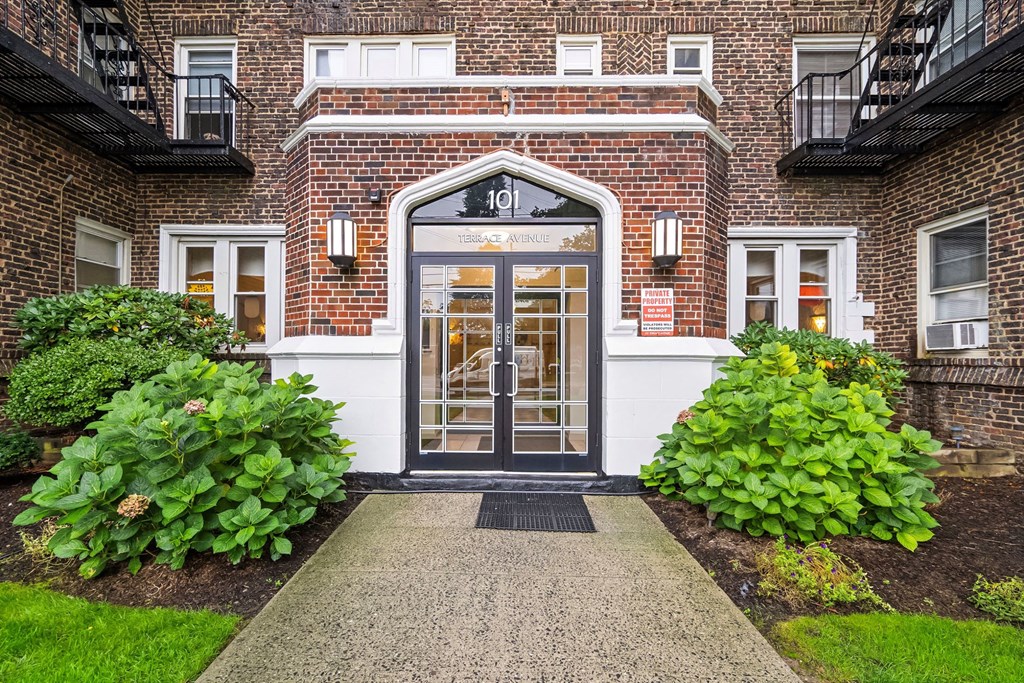 the front door of a building with plants in front of it
