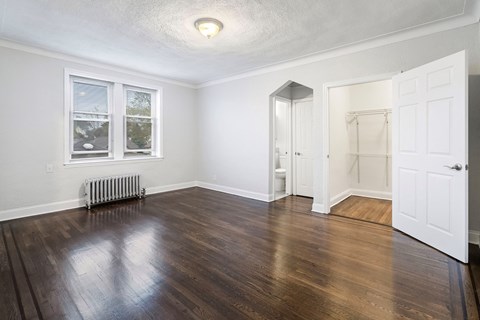 an empty living room with wood floors and a closet
