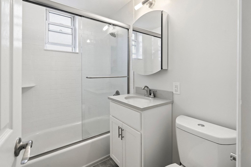 a white bathroom with a shower sink and toilet