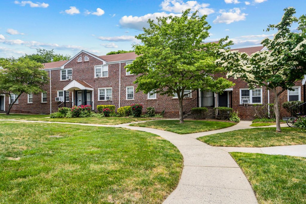 an apartment building with a sidewalk in front of it