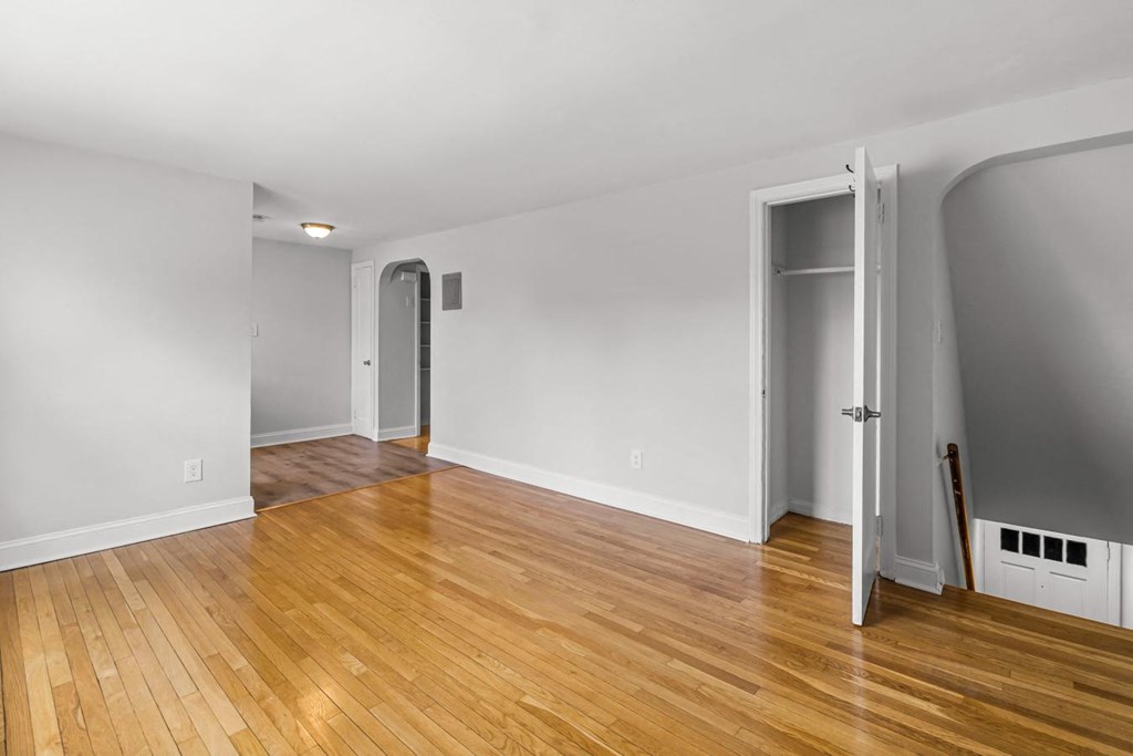 a living room with a hard wood floor and a door to a hallway