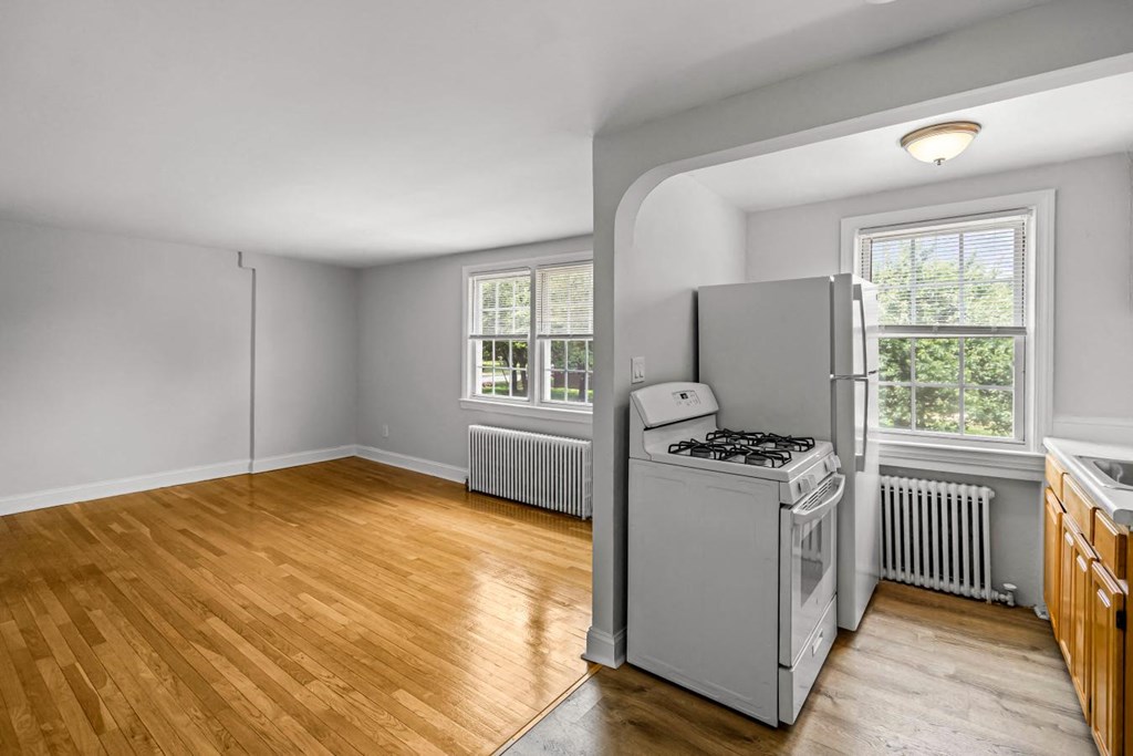 an empty kitchen with a stove and a refrigerator