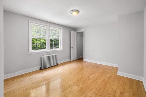 an empty living room with wood floors and a window
