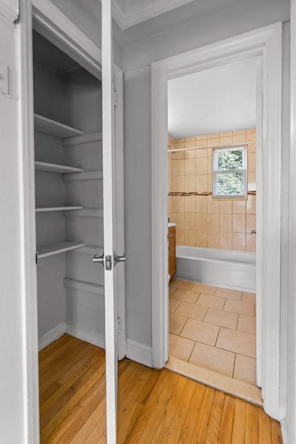 a small bathroom with a closet and a tiled floor